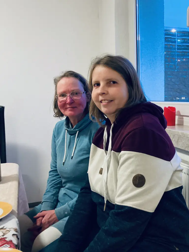 Sabine und Anne sitzen an einem Tisch im Gemeinschaftsraum